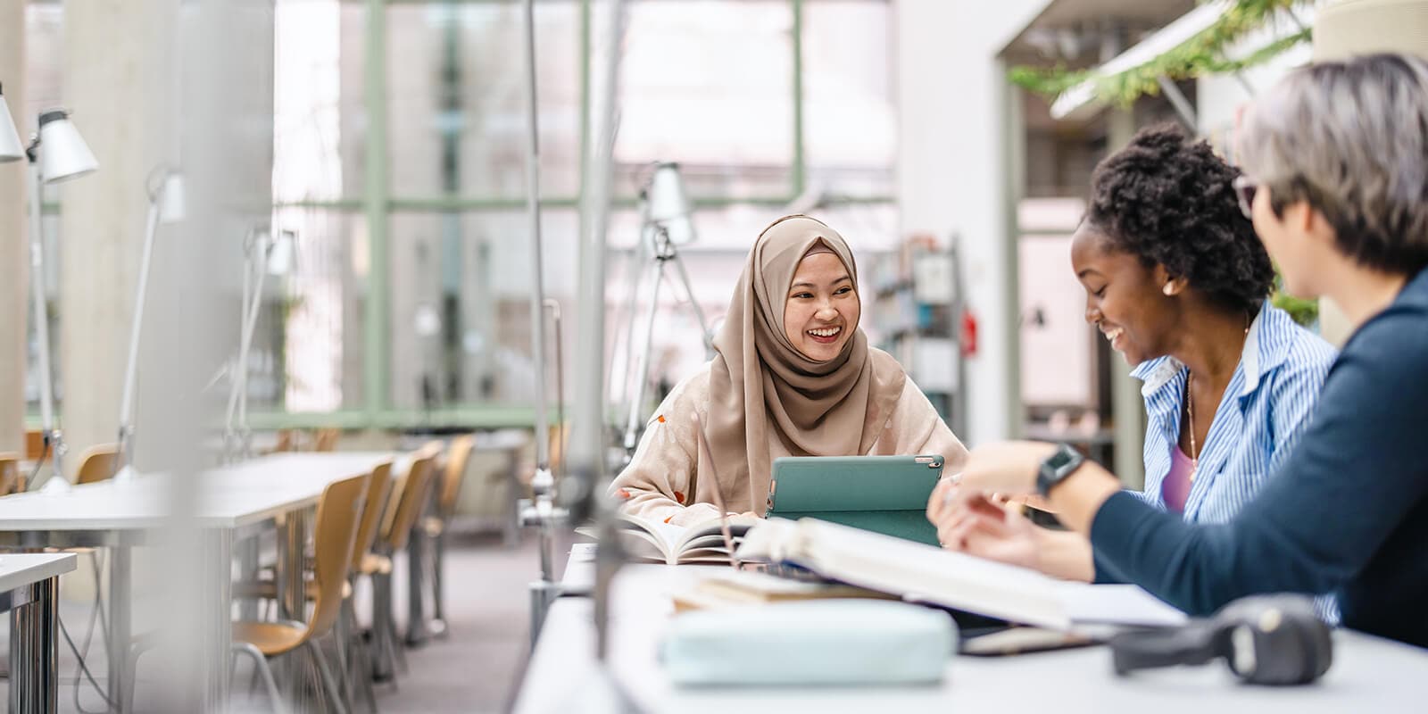 A student being interviewed by two individuals in a study space