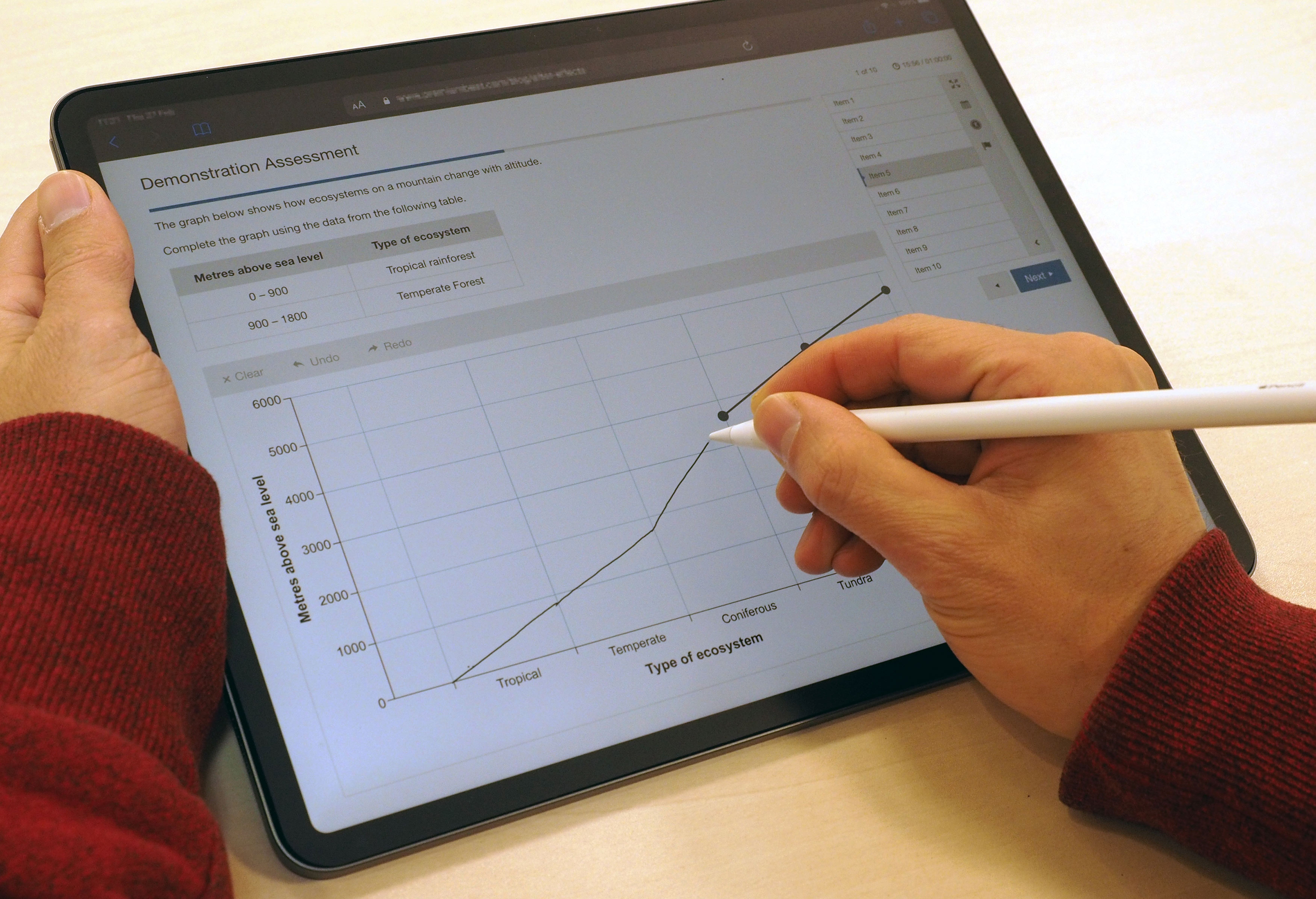 Learner using a stylus and tablet to answer questions in an onscreen, digital assessment