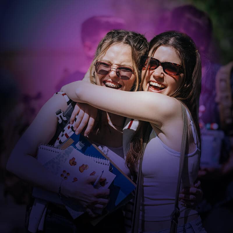 Two students hugging and celebrating