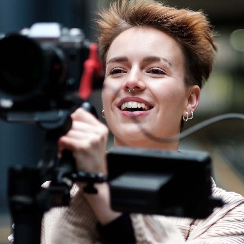 Young woman laughing behind a camera