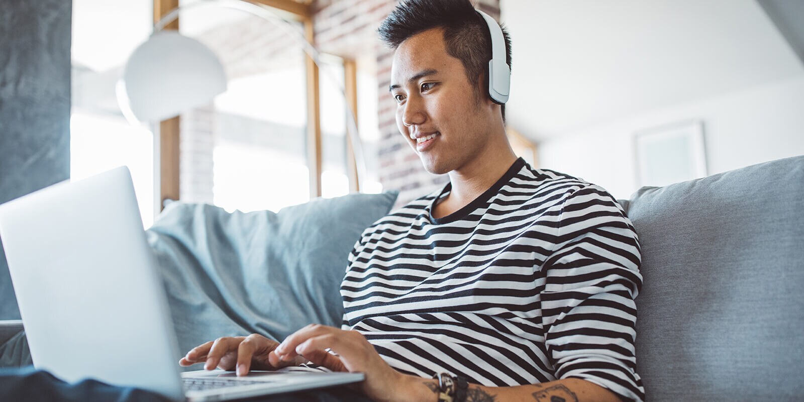 Young man on laptop with headset on