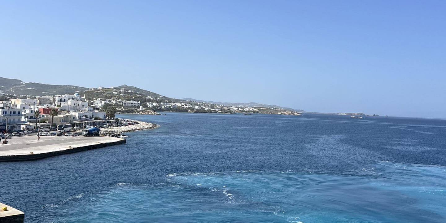 A view of a body of water with the shoreline with buildings in the distance.