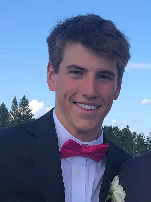 Blog author Cooper has short light brown hair. He is wearing a black tuxedo jacket over a white shirt with a red bowtie.