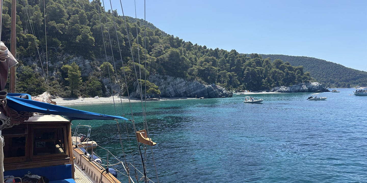 A view from a boat out to a small beach and hilly area. 