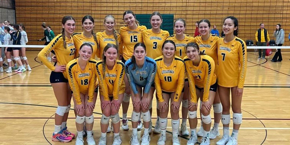 A Marquette University women’s club volleyball team photo in a gym.