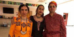 The blog author Suhani is standing between her mother and father. All three are wearing traditional Indian clothing.
