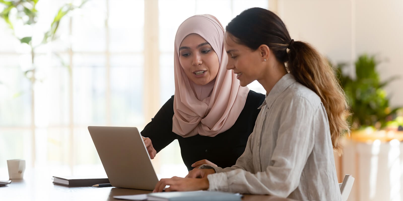 Two students discussing content on the laptop in front of them