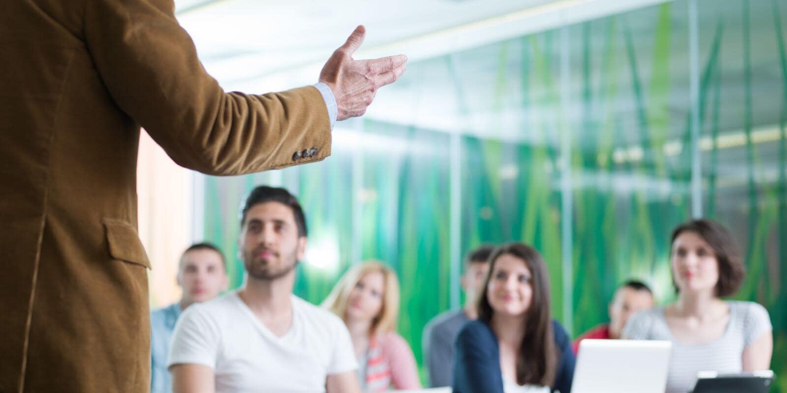 An instructor standing in front of a room of young adult students