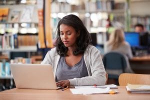 Young woman on her laptop in the library. 