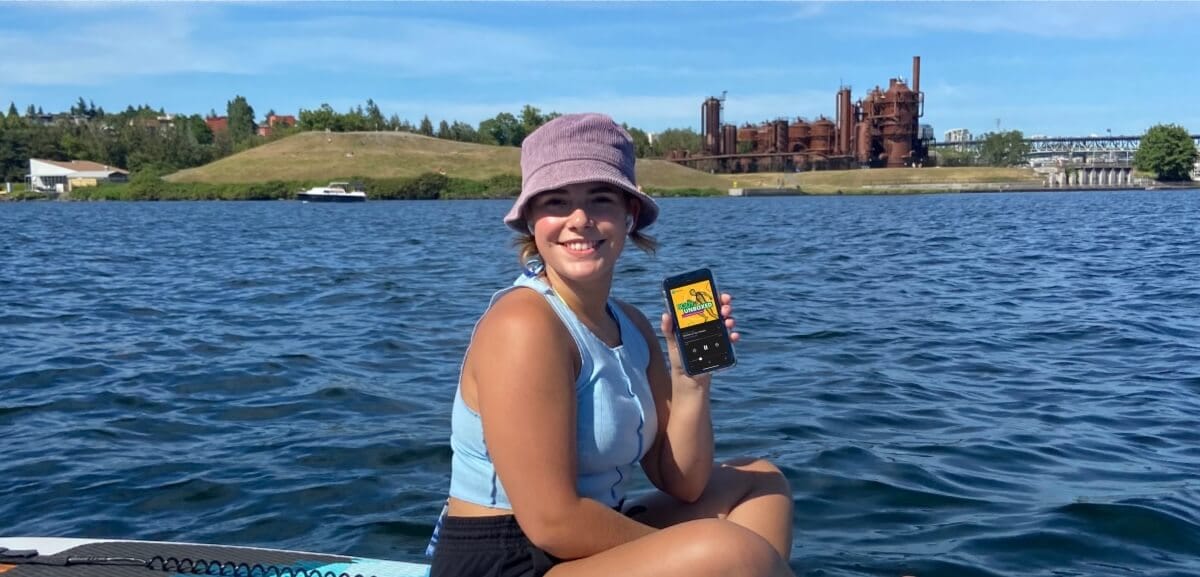 Blog author Mikayla Wallace on a paddle board with her phone. 
