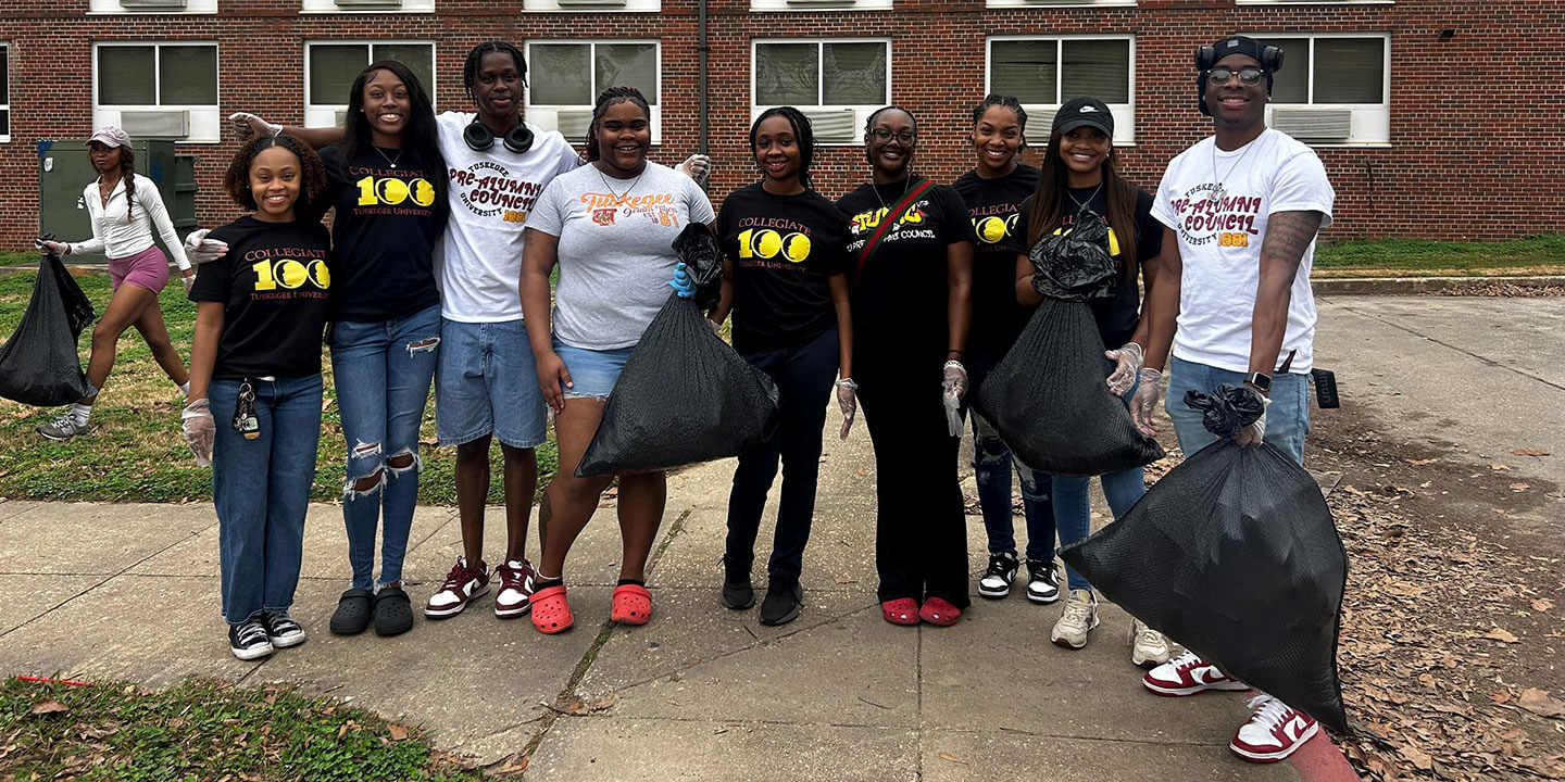 Nine students standing outside a building on campus.