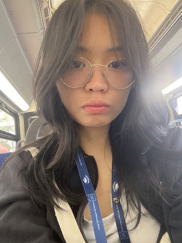 The blog author has glasses and long dark hair and is wearing a black zip up jacket over a white shirt.