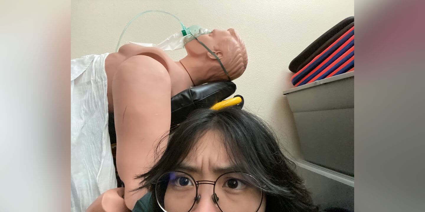 Image shows a medical mannequin in front of a wide-eyed student.