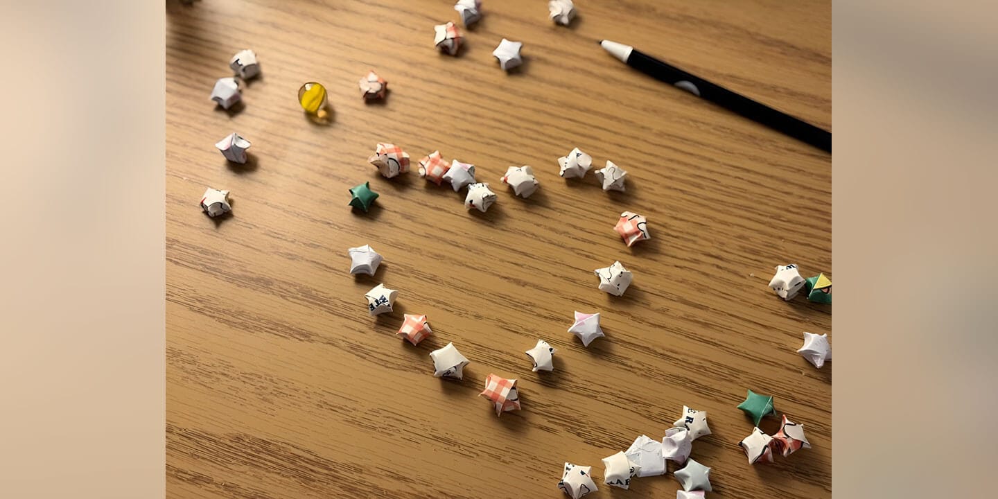 Origami paper stars arranged in a heart pattern.