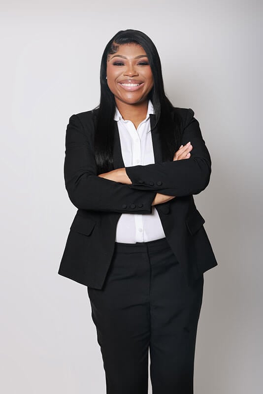 The blog author, Jykya, has long dark hair and is wearing a black suit with a white dress shirt.