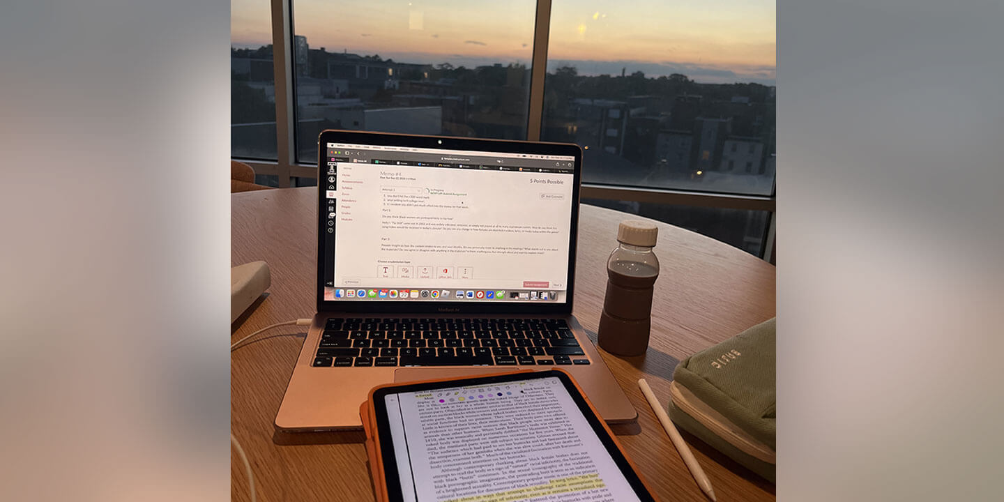 A laptop and tablet open to academic coursework for studying.