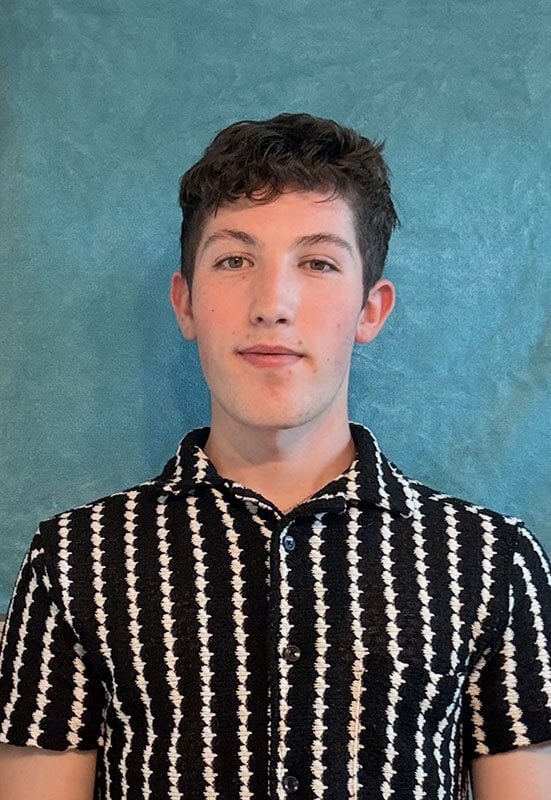 The blog author, Logan, has dark hair and is wearing a vertical striped black and white shirt.