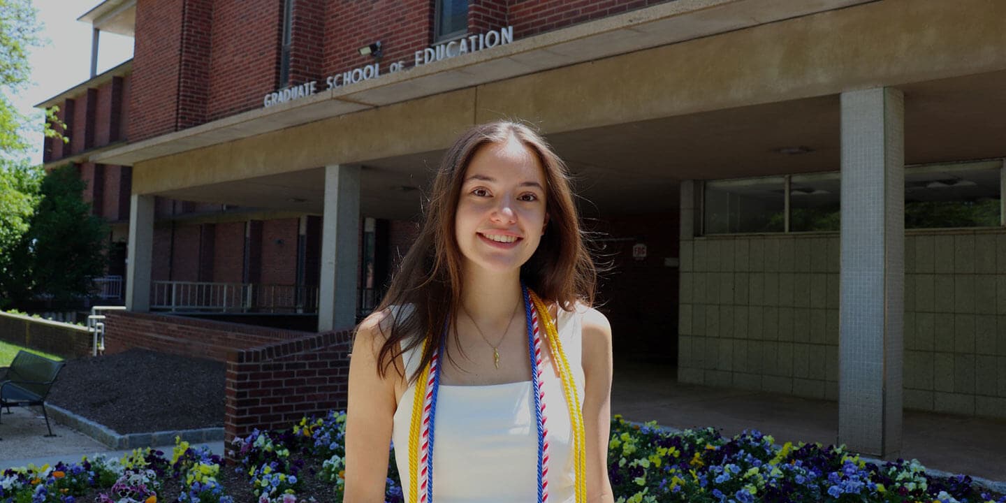 Blog author Maddy standing in front of the Graduate School for Education building on her campus.