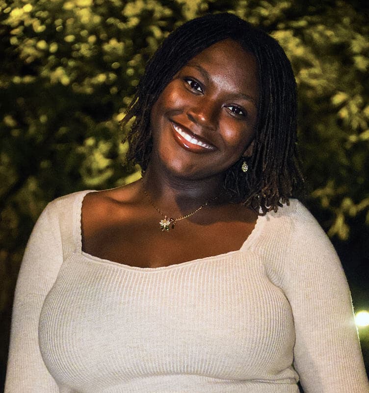 The blog author, Makayla, has dark, medium length braids and is wearing a cream-colored shirt with a gold necklace.