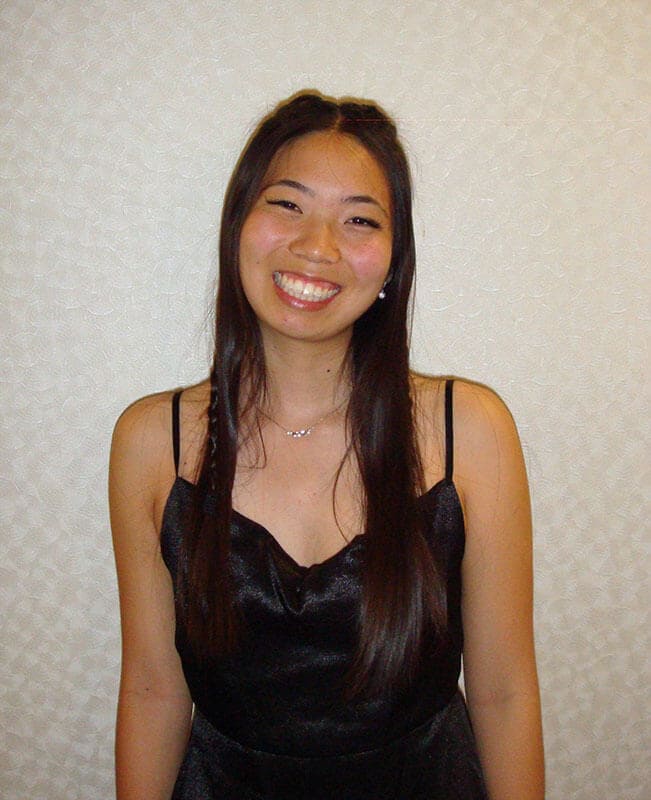 The blog author, Megan, has long dark hair and and is wearing a black dress with thin straps.
