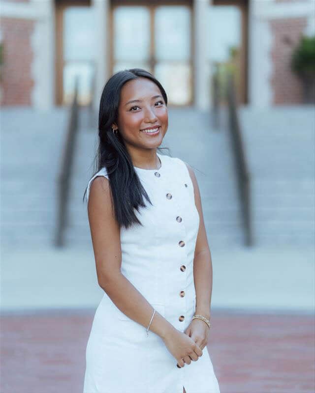 The blog author, Michelle, has long dark hair, and is wearing a white sleeveless dress with buttons up the front.