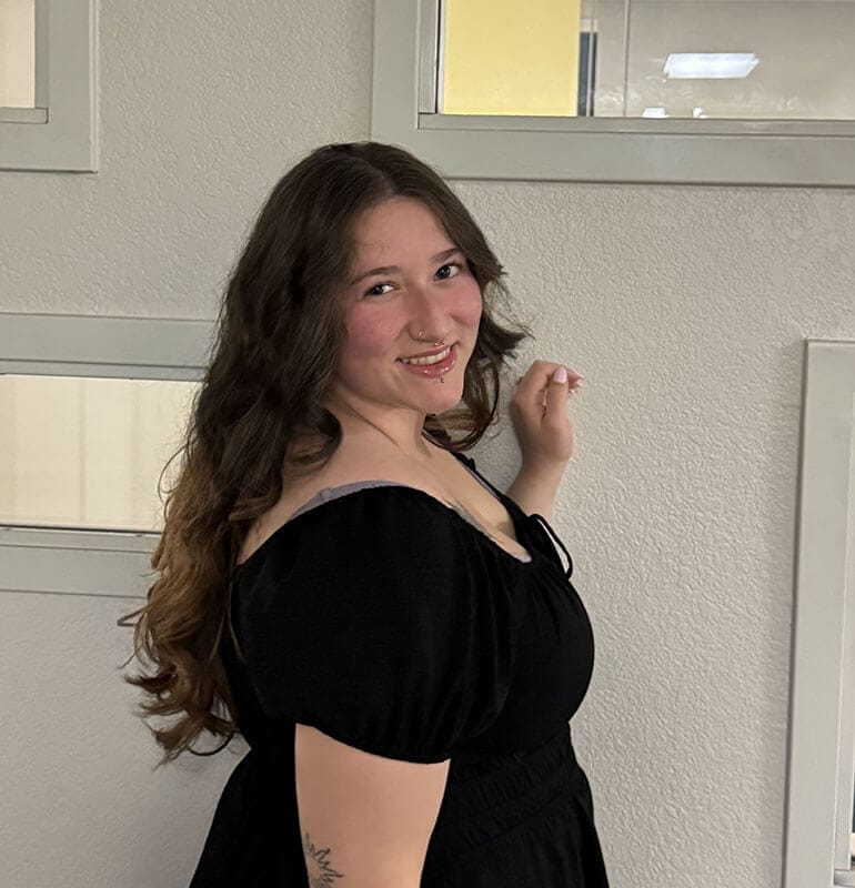 The blog author, Meredith, has long, dark, wavy hair and is wearing a black dress.