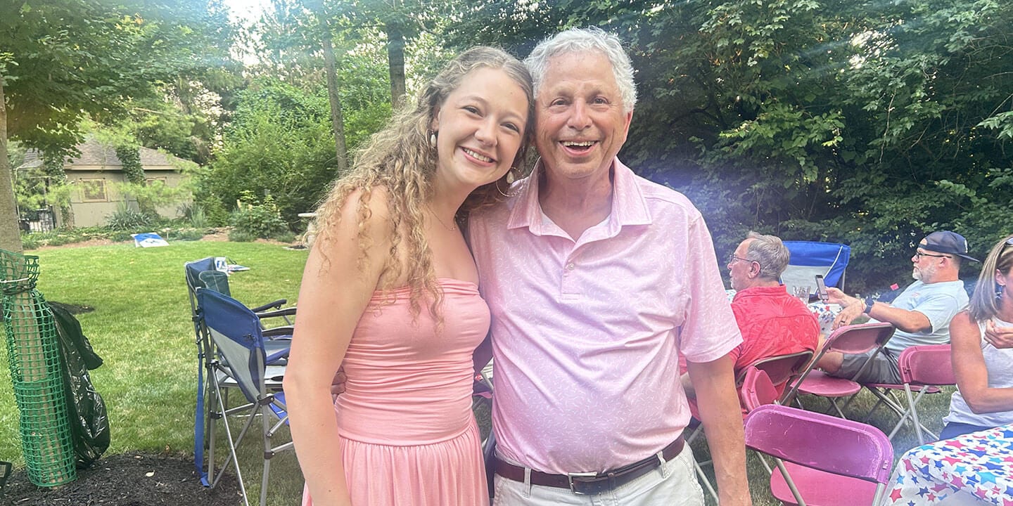 The blog author and her grandfather are standing outside at a picnic.