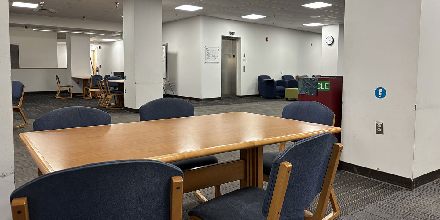 An empty room filled with tables and comfortable chairs.