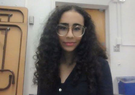 Blog author Arwa has wavy long dark hair and is wearing horn-rimmed glasses and a dark blouse.