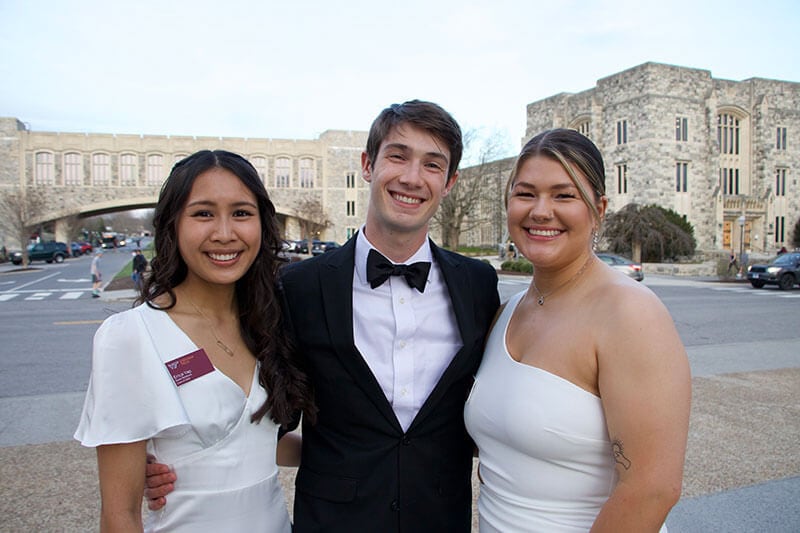 Blog author Erica Yap is pictured here with two classmates at a formal event at Virginia Tech. Erica is on the left in a formal white dress. Another female is on the right side, also wearing a white formal dress. A young male college student stands between them wearing a tuxedo.