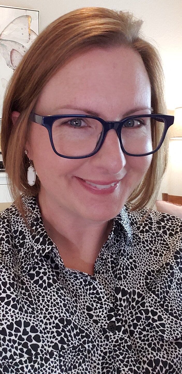 Blog author LeeAnn Ridgley has short red hair and is wearing black horned-rimmed glasses and a black-and-white print blouse.