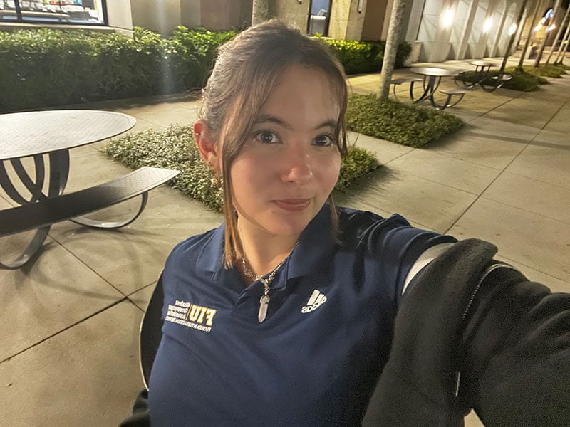 A selfie of blog author Melanie. She has dark hair pulled back and is wearing a dark hooded jacket over her FIU Student Government polo shirt. 