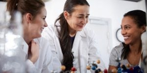 Female scientist working in the lab with students 
