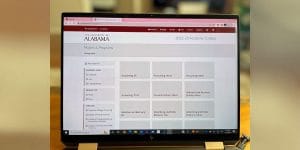 A computer laptop screen displaying the 2022-2023 Academic Catalog of the University of Alabama.