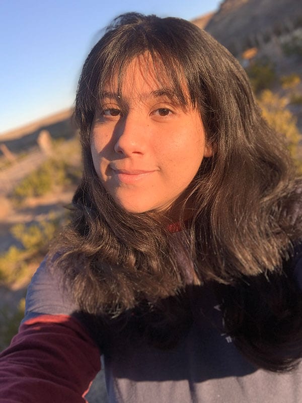 A selfie of blog author Soledad out on a hiking trail. She has medium length dark hair with bangs.