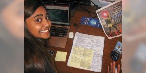 Blog author Tahmina with a composition notebook filled with engineering notes.