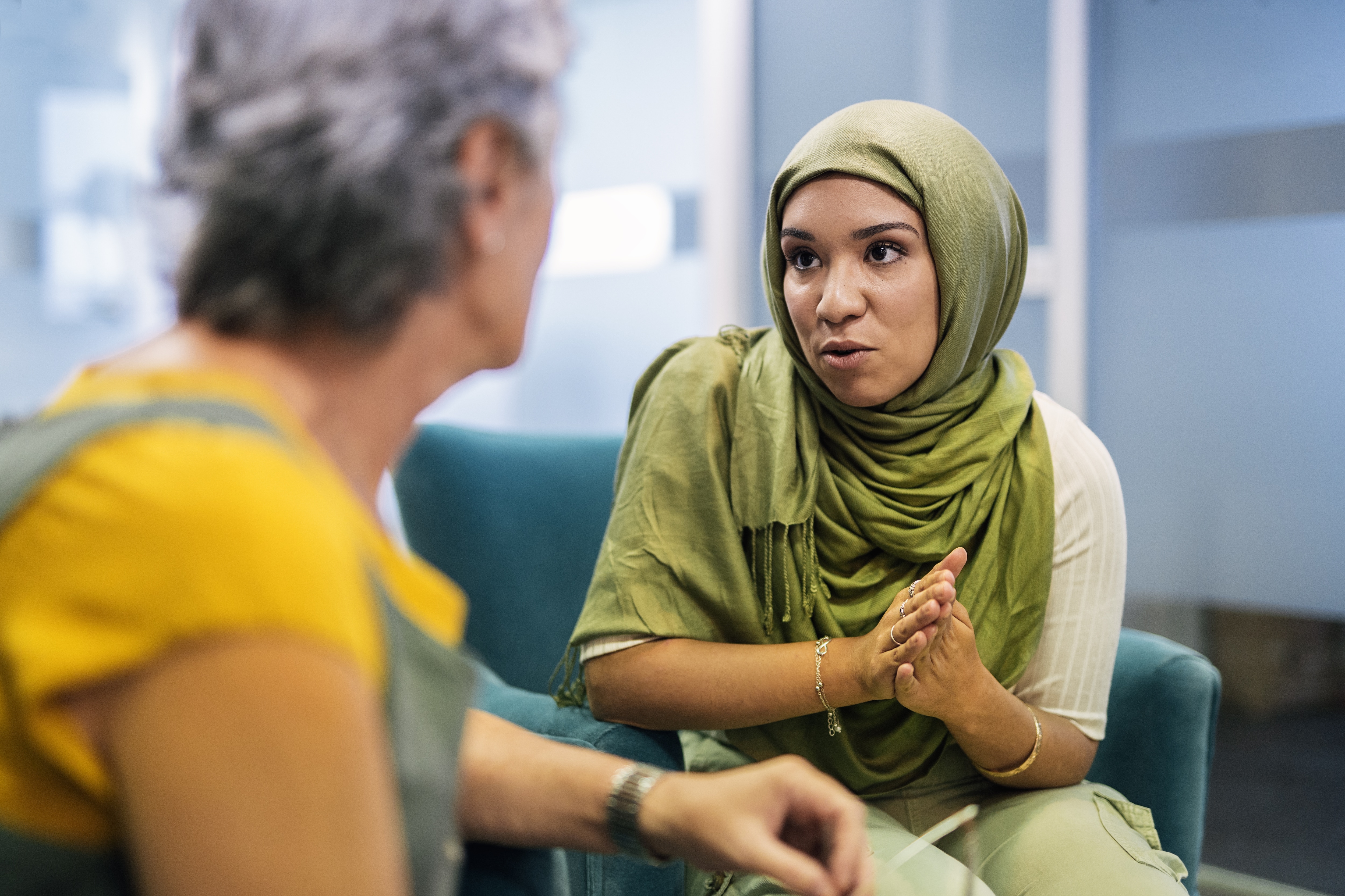 Young woman speaking with another person.