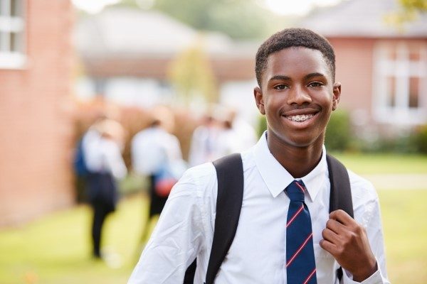 student standing outside school building