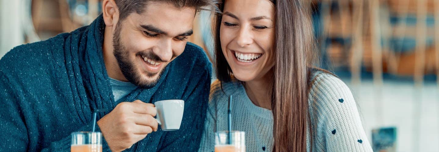 زوجان يضحكان معا أثناء تناول المشروبات