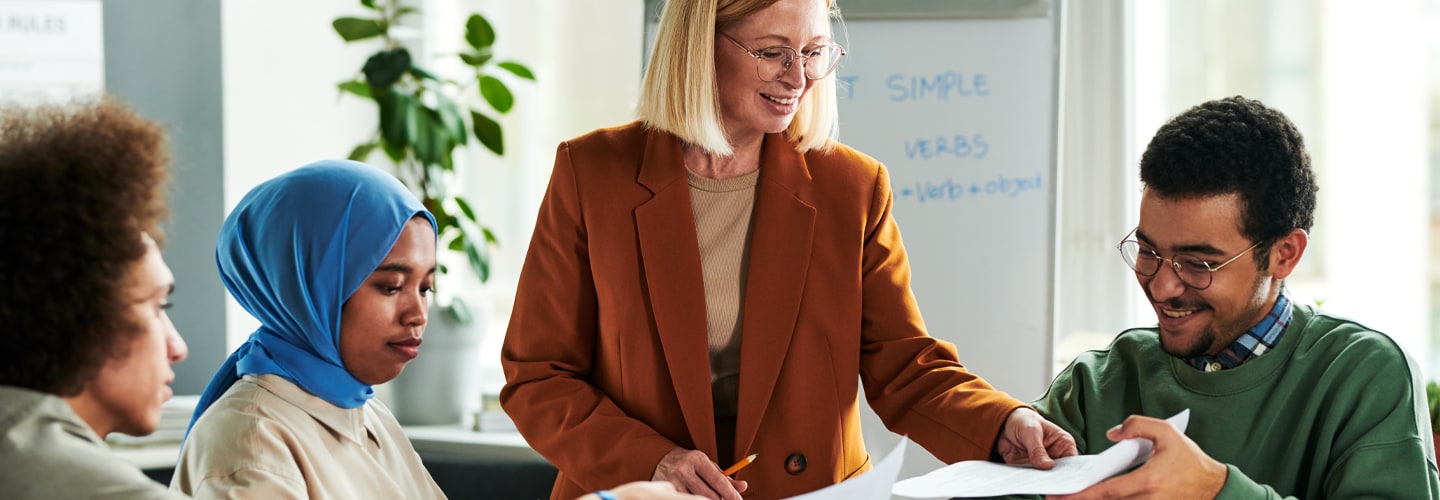 A teacher handing out papers to her students