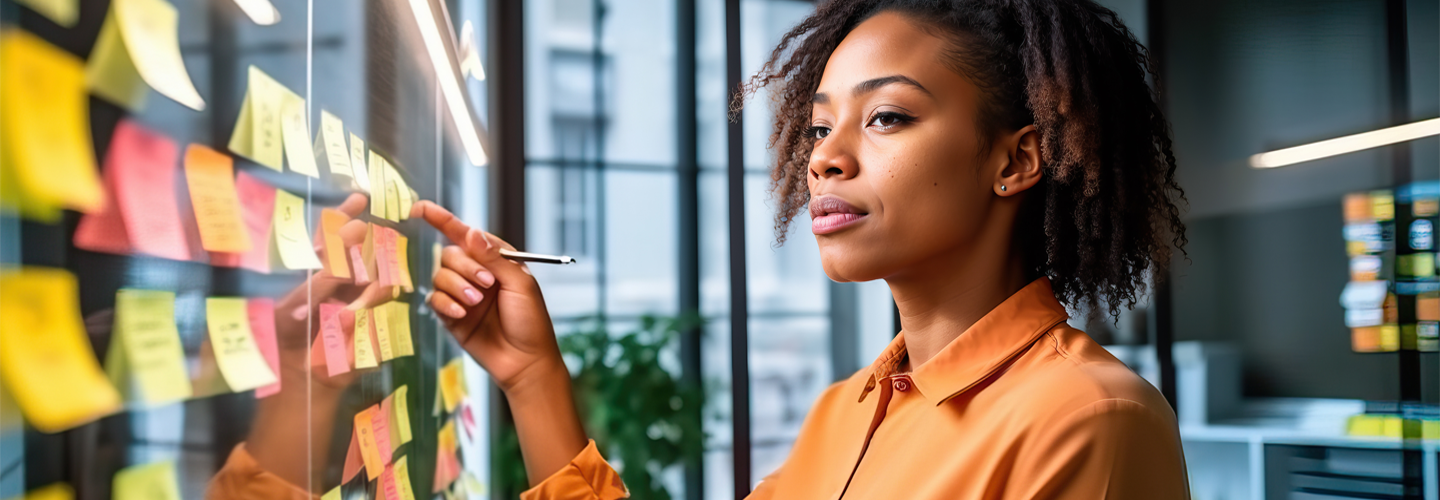 A business woman looking and pointing at a wall full of post it notes
