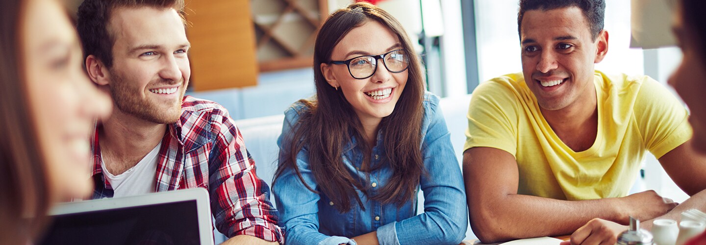 College students sat together at a table smiling