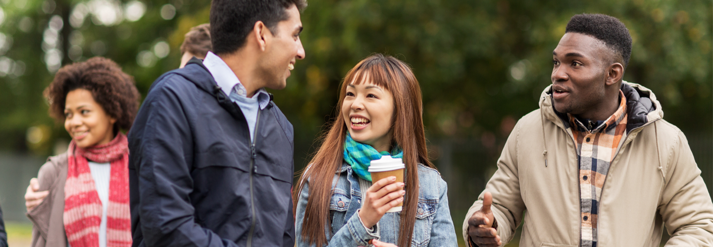 Friends walking outdoors chatting to eachother
