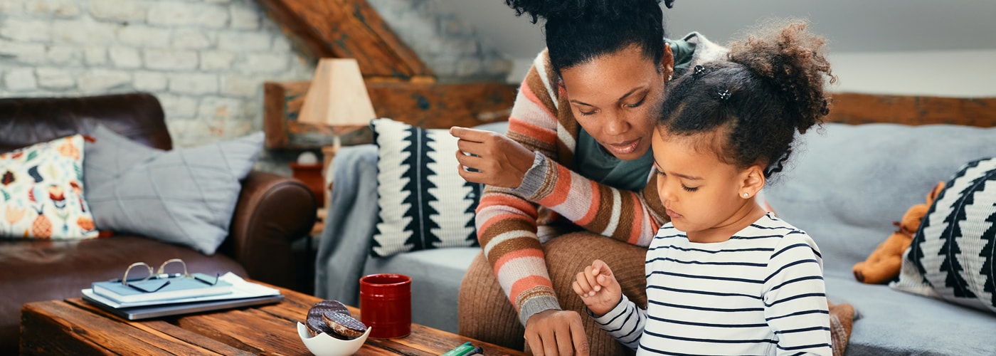 A parent with her child working together in a living room