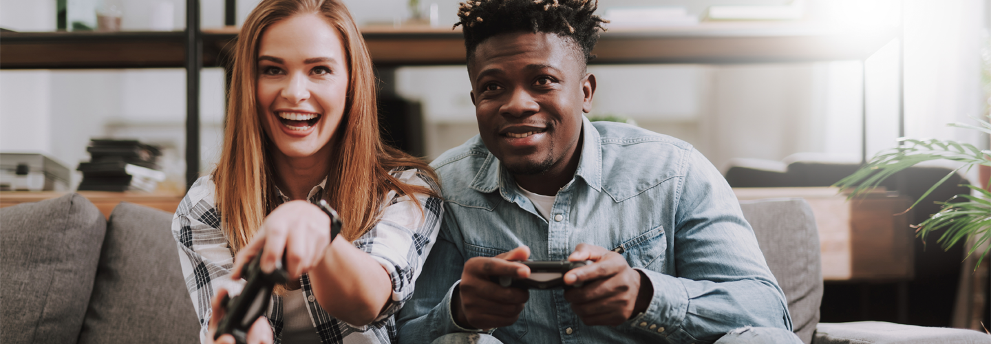 Two people playing video games on the sofa together