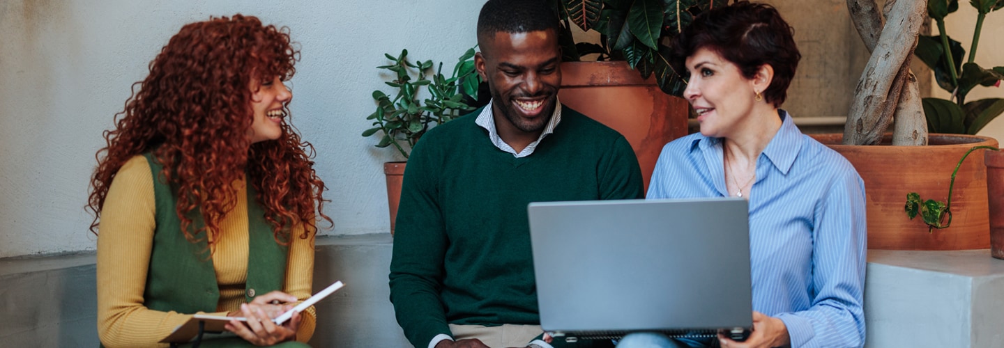 A team of professionals talking together with a laptop