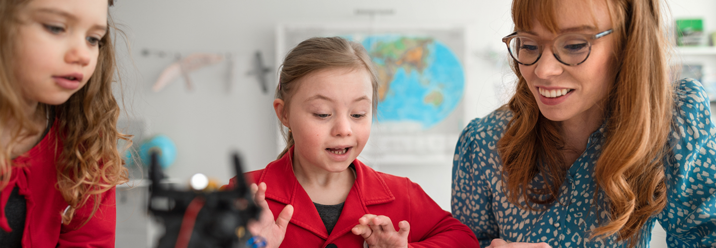 A teacher with students working together on electronics
