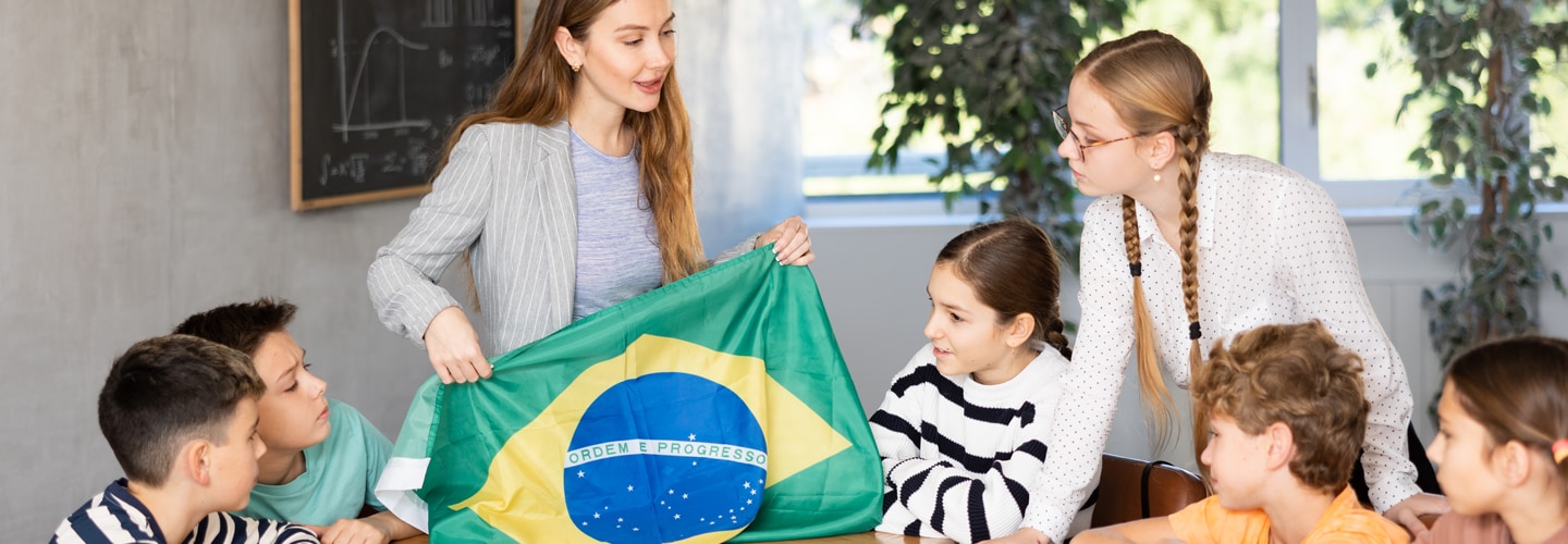 Teacher in class with students holding Brazil flag
