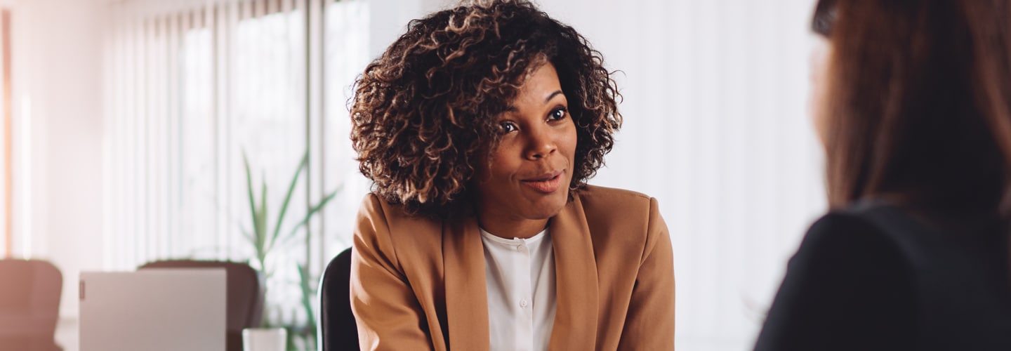 A woman talking in a professional space to another person