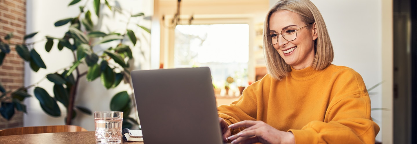 A woman on her laptop smiling and working